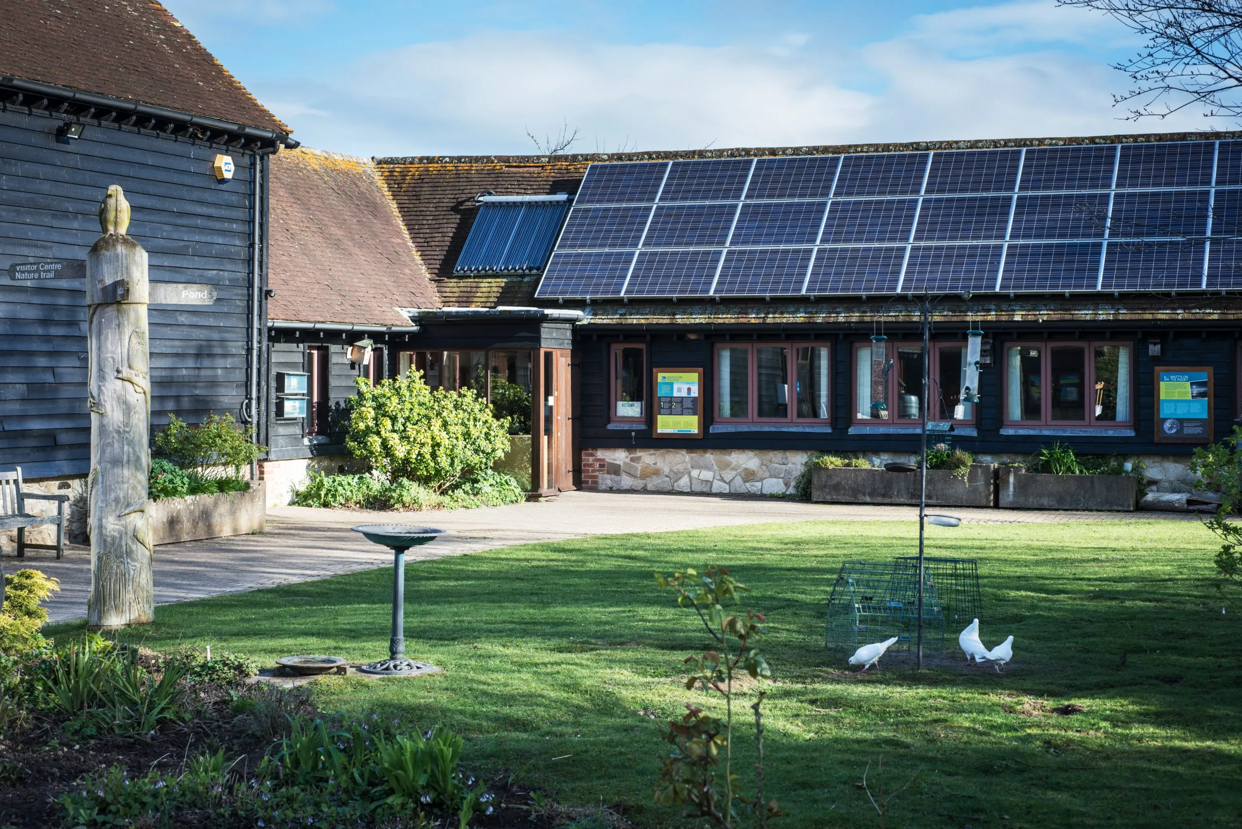 An RSPB building with a collection of solar panels affixed to the roof.