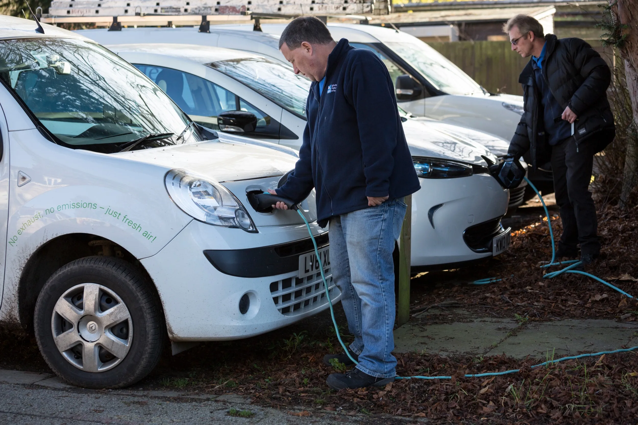 Two RSPB Staff members charging electric vehicles.
