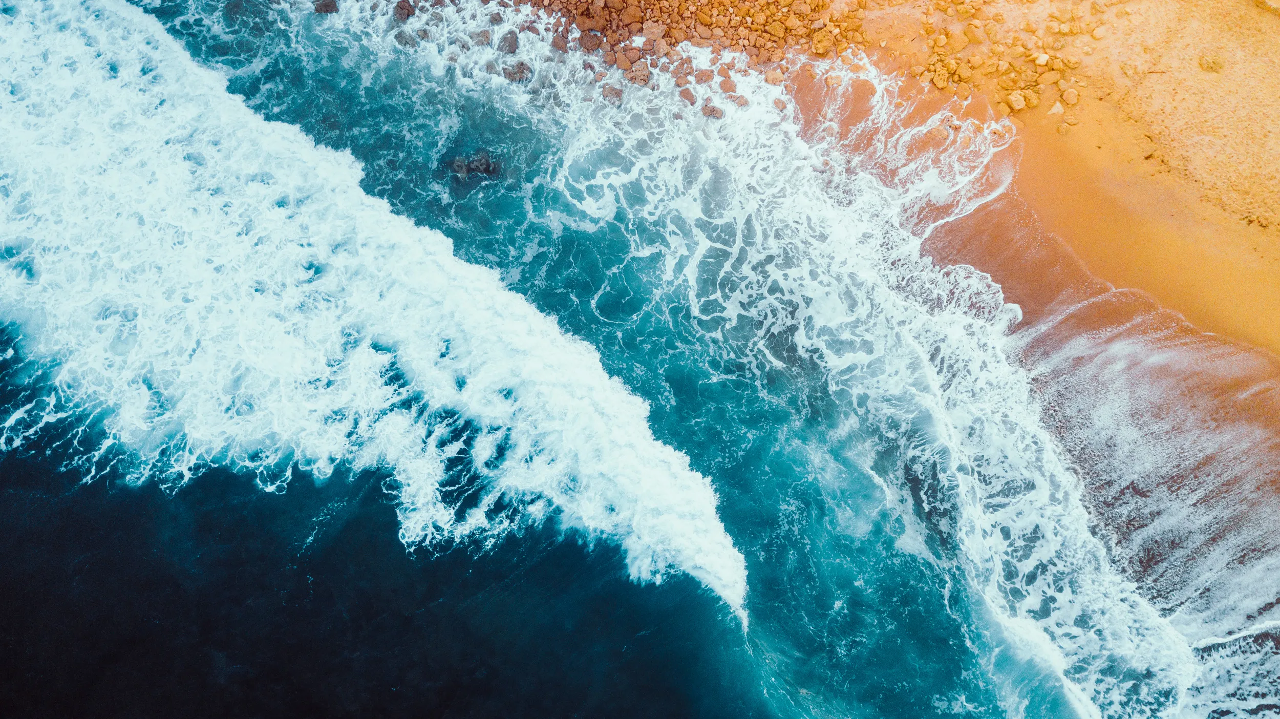 Stormy blue waves hitting a vibrant yellow shoreline