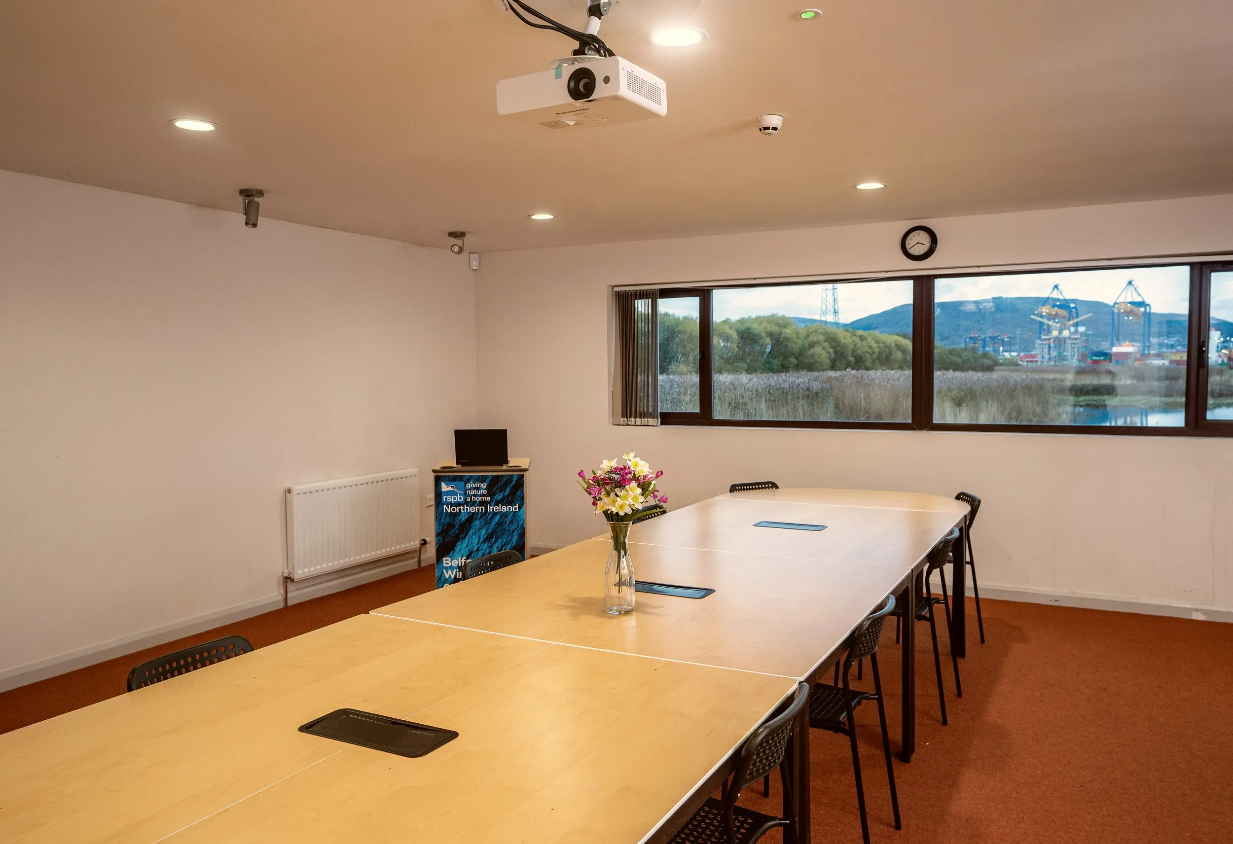 A meeting room with a window overlooking wetland.