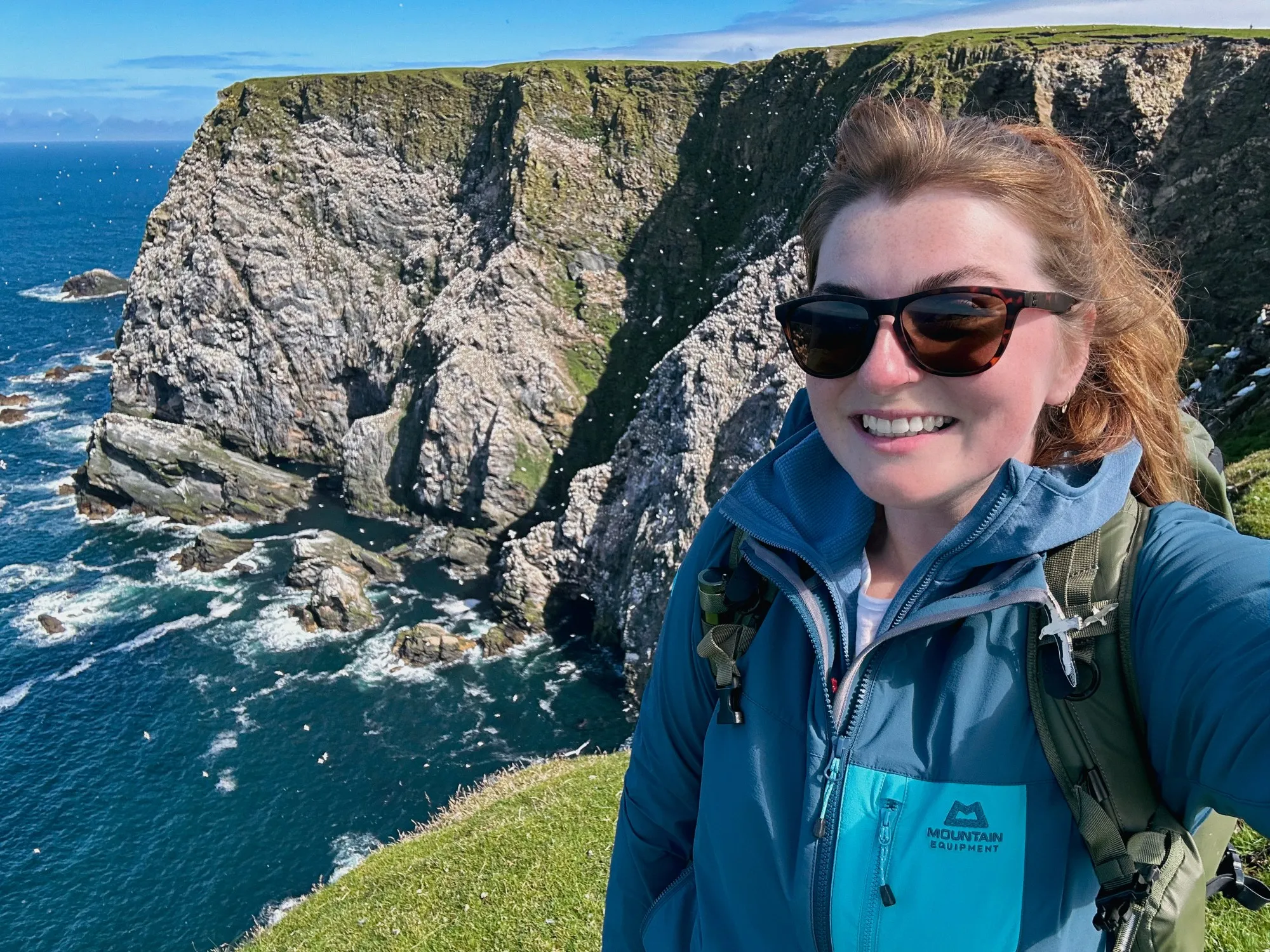 Rachel Bigsby smiling against a background of cliffs